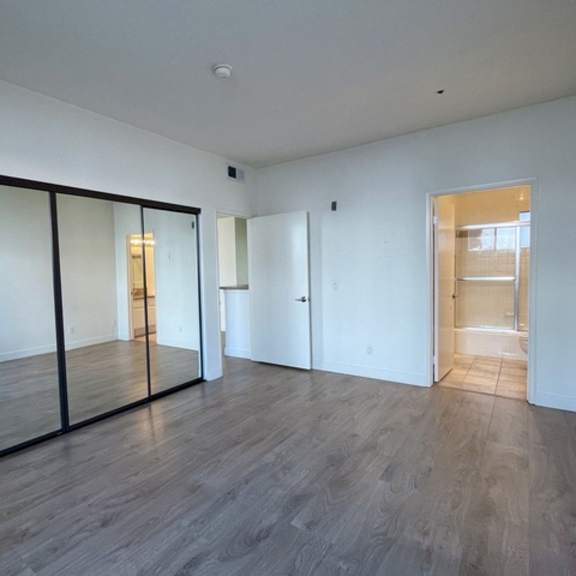 Thumbnail 25 of 26 A room with a wooden floor and white walls.