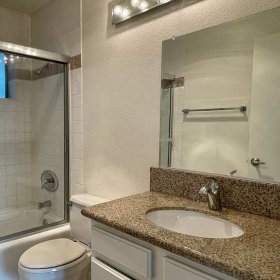 Thumbnail 22 of 26 A bathroom with a toilet, sink, and shower.