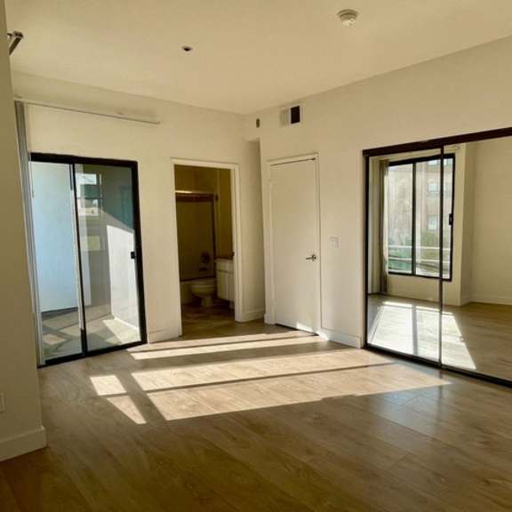 Thumbnail 26 of 26 A room with a sliding glass door and a rug on the floor.