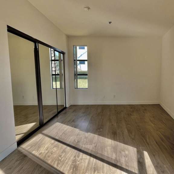Thumbnail 24 of 26 A room with wooden flooring and a window.