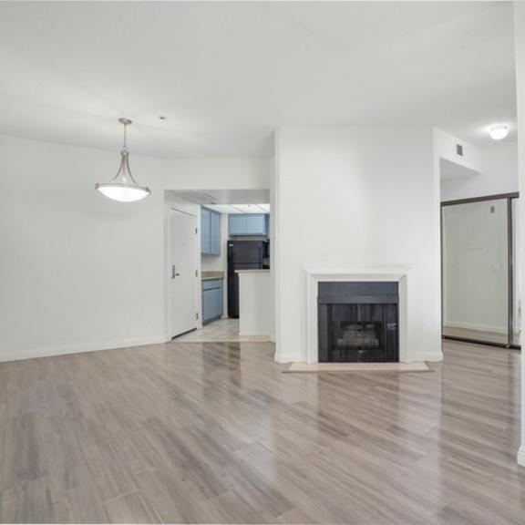 Thumbnail 10 of 11 A spacious living room with a fireplace and hardwood floors.