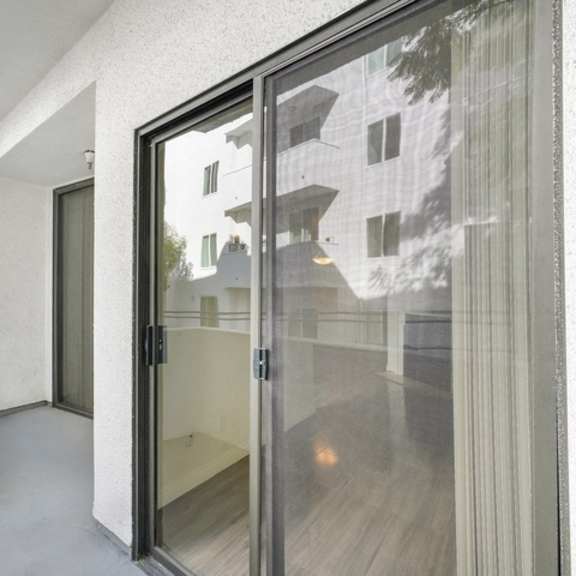 Thumbnail 2 of 11 A modern house with a glass door leading to a balcony.