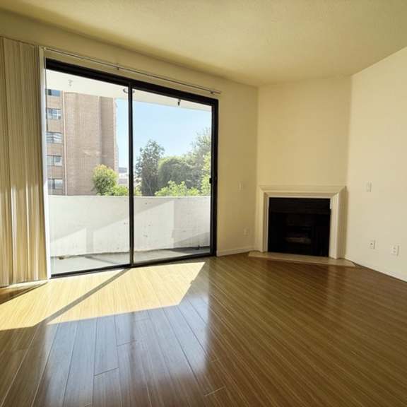 Thumbnail 8 of 18 A room with a fireplace and sliding glass doors.