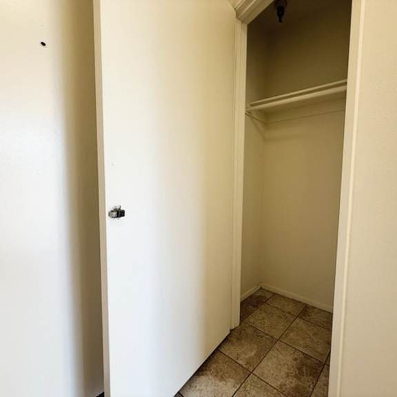 Thumbnail 2 of 18 A white door is open to a small, empty room with a tiled floor.