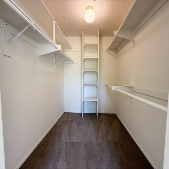 Thumbnail 14 of 18 A small, empty room with a ladder in the middle.