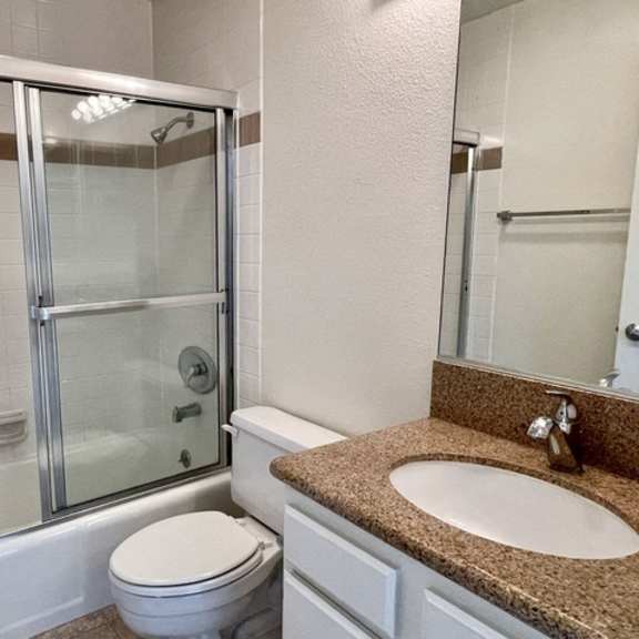 Thumbnail 3 of 27 A bathroom with a toilet, sink, and shower.