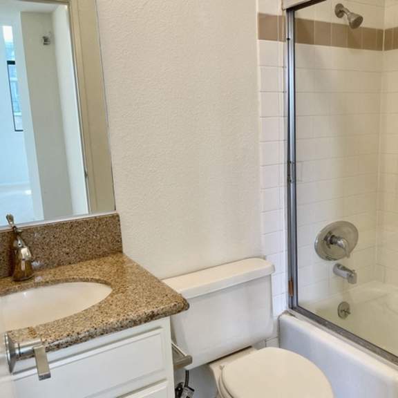 Thumbnail 6 of 27 A white toilet sits next to a sink in a bathroom.