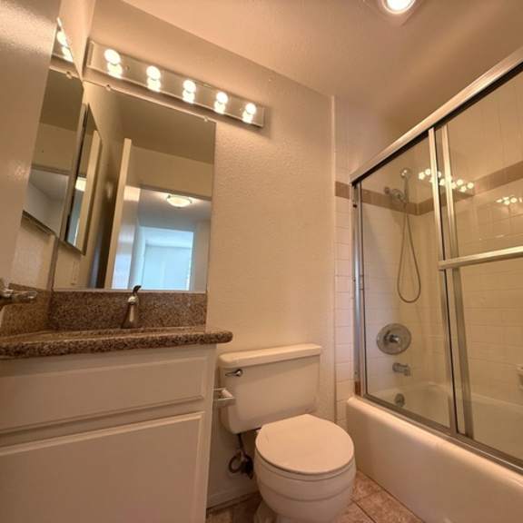 Thumbnail 26 of 27 A white toilet sits next to a bathtub in a bathroom.