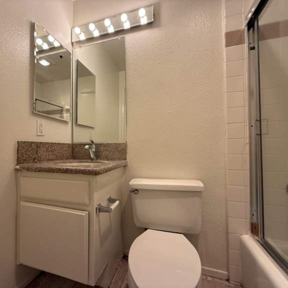 Thumbnail 13 of 27 A white toilet sits next to a sink in a small bathroom.