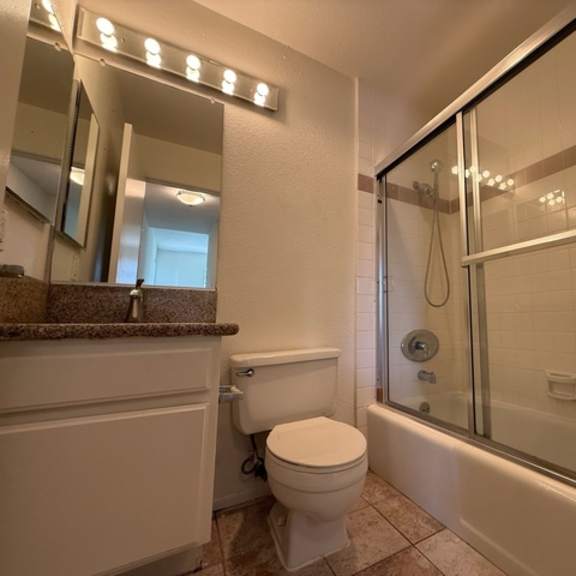 Thumbnail 21 of 27 A white toilet sits in a bathroom next to a bathtub.