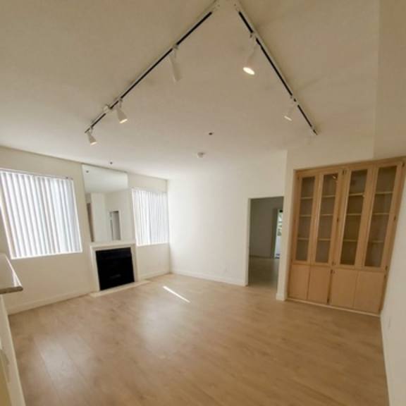 Thumbnail 5 of 9 A room with wooden flooring and a large window.