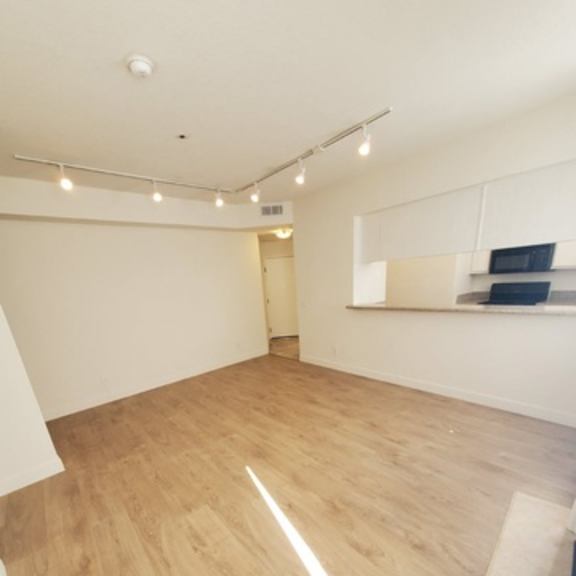 Thumbnail 7 of 9 A room with wooden flooring and white walls.