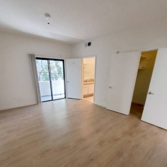 Thumbnail 6 of 9 A room with wooden flooring and white walls.