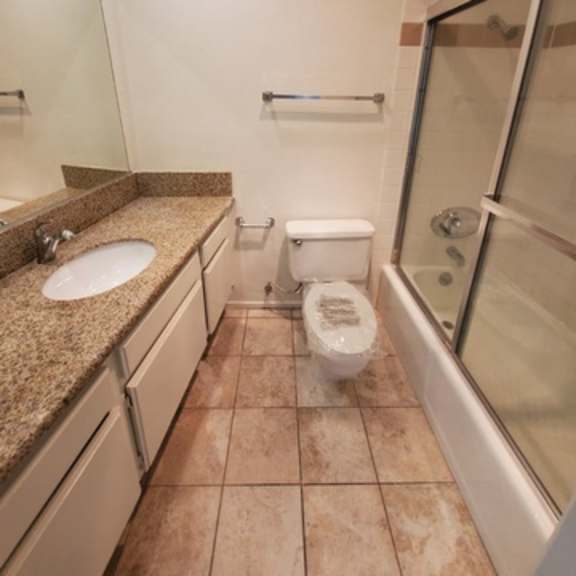 Thumbnail 3 of 9 A bathroom with a toilet, sink, and bathtub.