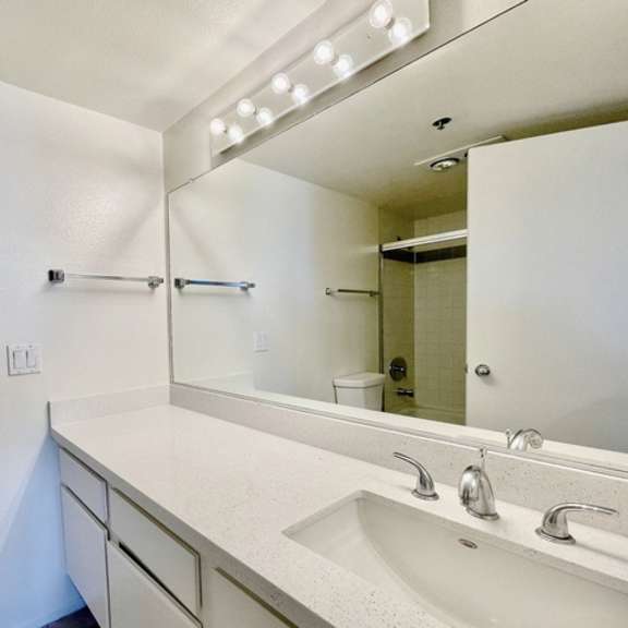 Thumbnail 15 of 31 A bathroom with a white sink and a mirror above it.