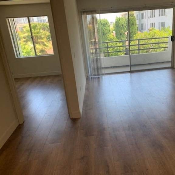 Thumbnail 5 of 12 A room with wooden floors and a fireplace with a balcony outside.