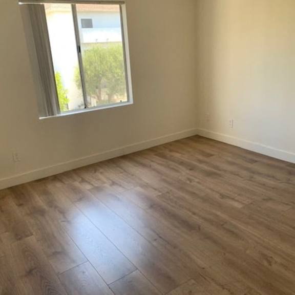 Thumbnail 8 of 12 A room with wooden flooring and a window.