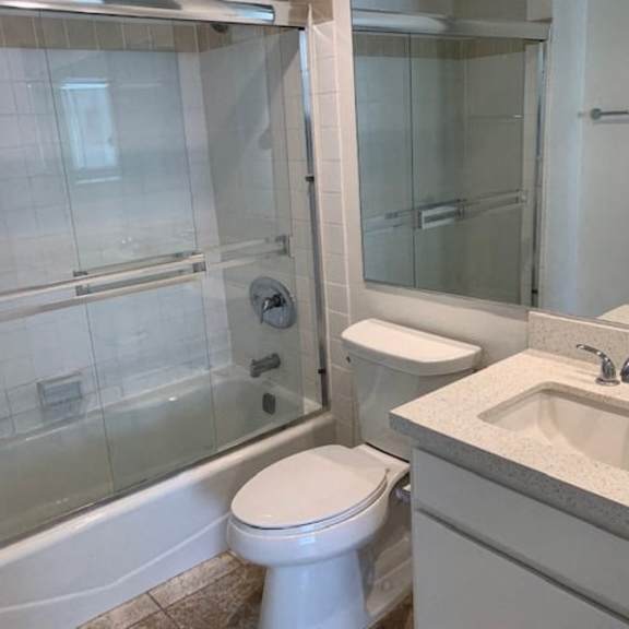 Thumbnail 8 of 16 A white toilet sits next to a sink in a bathroom.
