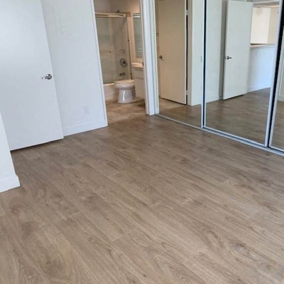 Thumbnail 15 of 16 A room with a wooden floor and a white door.
