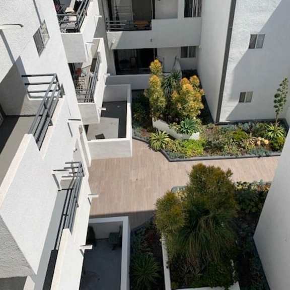 Thumbnail 13 of 16 A view of a courtyard from a high angle with trees and plants.
