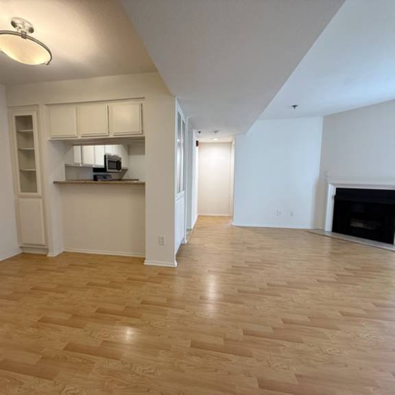 Thumbnail 9 of 53 A spacious living room with a fireplace and hardwood floors.