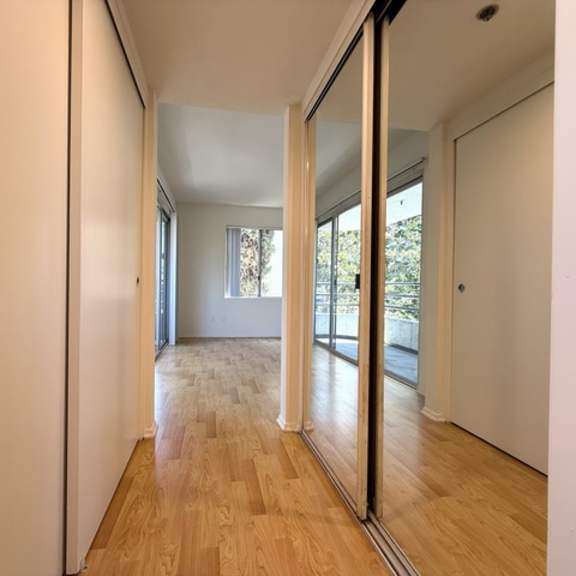 Thumbnail 11 of 53 A hallway with a wooden floor and white walls.