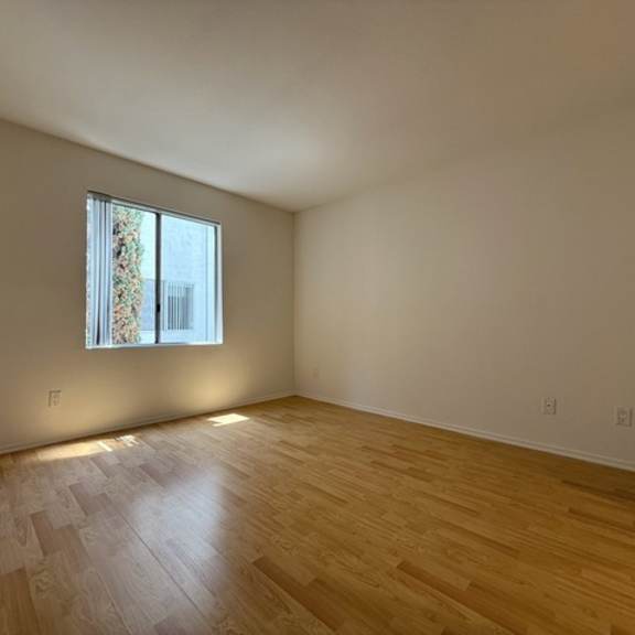 Thumbnail 20 of 53 A room with a window and wooden flooring.