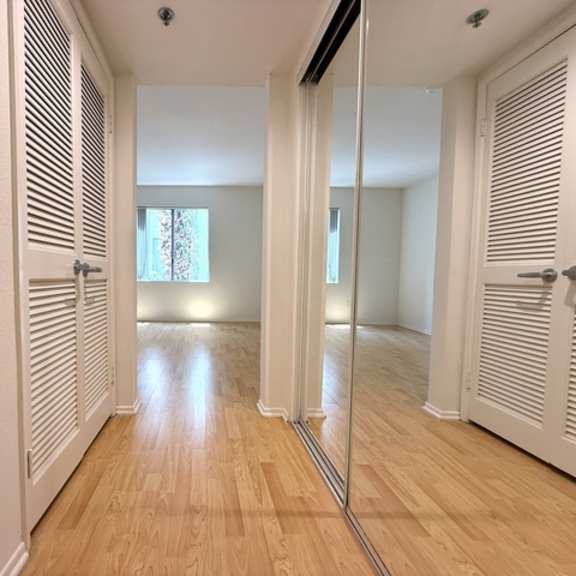 Thumbnail 17 of 53 A hallway with wooden floors and white walls.