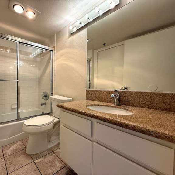 Thumbnail 13 of 53 A bathroom with a toilet, sink, and shower.