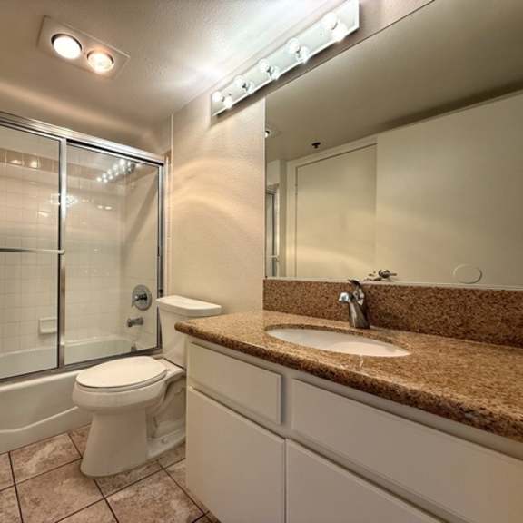 Thumbnail 12 of 53 A bathroom with a toilet, sink, and shower.