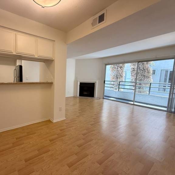 Thumbnail 18 of 53 A room with wooden floors and a white fridge.