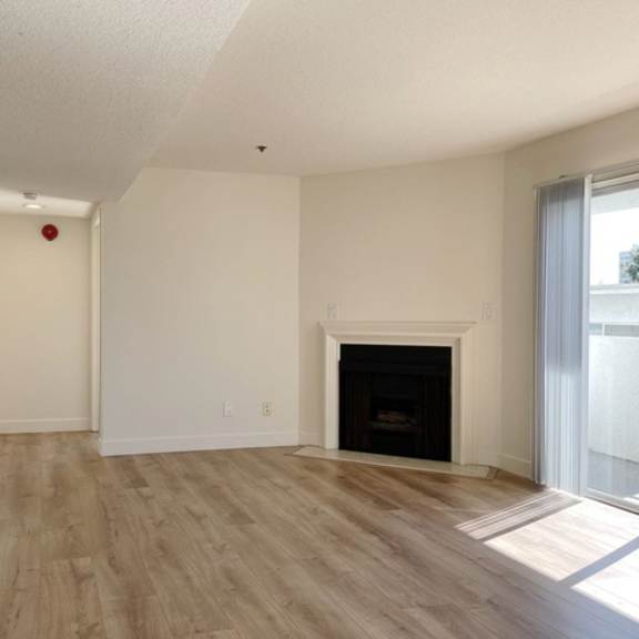 Thumbnail 7 of 17 A room with a fireplace and wooden floors.