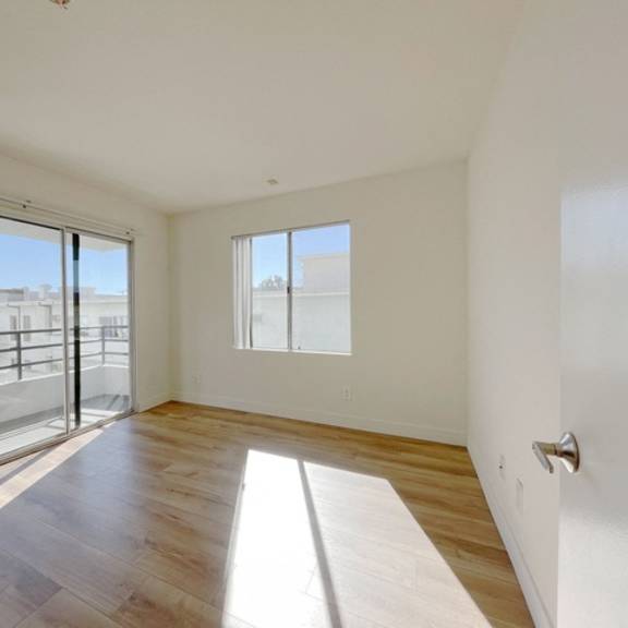 Thumbnail 14 of 17 A room with a sliding glass door leading to a balcony.
