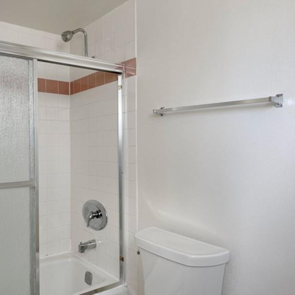 Thumbnail 12 of 17 A white toilet is in a bathroom with a glass shower door.