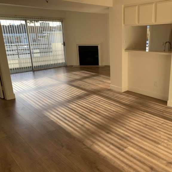 Thumbnail 2 of 8 A room with wooden flooring and white walls.