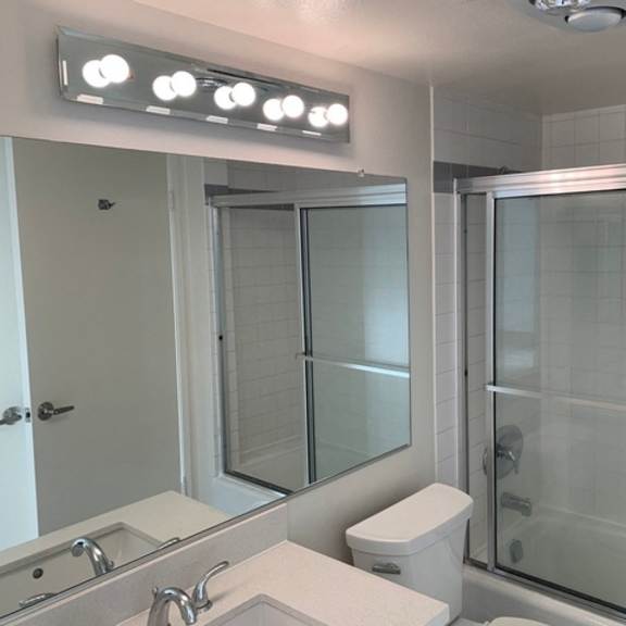 Thumbnail 6 of 8 A bathroom with a toilet, sink, and shower.