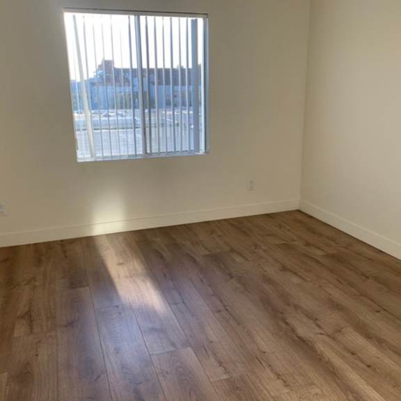 Thumbnail 5 of 8 A room with wooden flooring and a window.