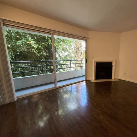 Thumbnail 13 of 28 A living room with a fireplace and sliding glass doors.