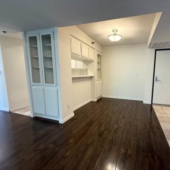Thumbnail 16 of 28 A kitchen with white cabinets and a wooden floor.