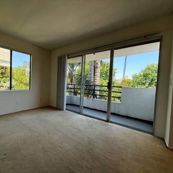 Thumbnail 22 of 28 A room with a large window and sliding glass doors.