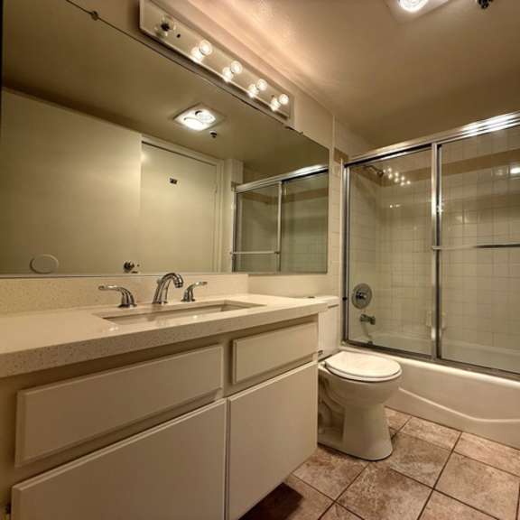 Thumbnail 25 of 28 A bathroom with a toilet, sink, and shower.