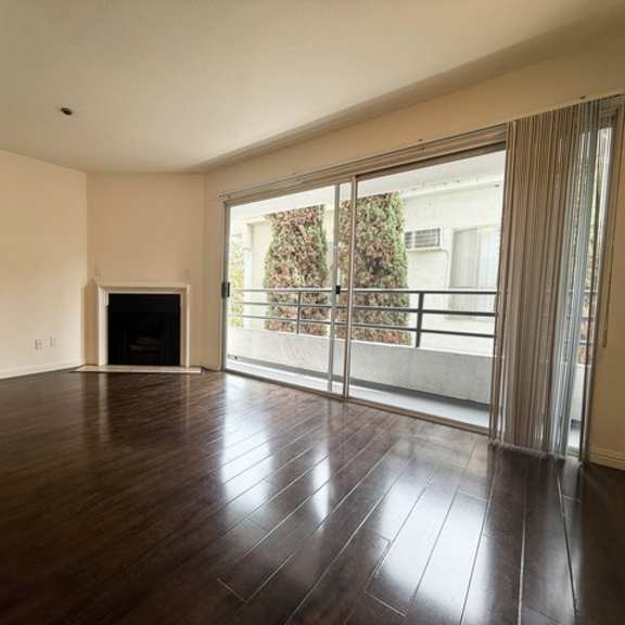 Thumbnail 15 of 53 A spacious room with a fireplace and sliding glass doors.