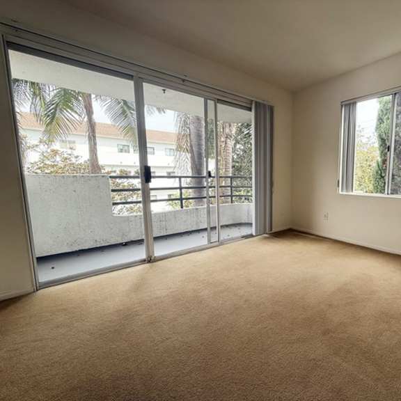 Thumbnail 23 of 53 A room with carpeted floor and sliding glass doors.