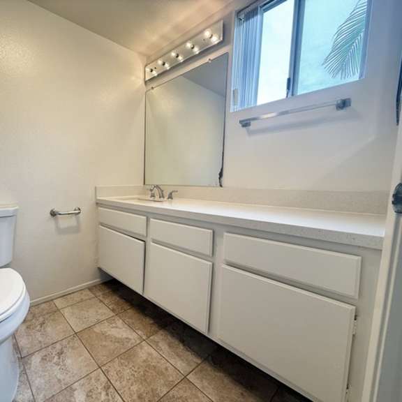 Thumbnail 26 of 53 A white toilet and sink in a small bathroom.