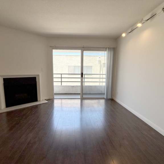 Thumbnail 12 of 15 A room with a fireplace and sliding glass doors.