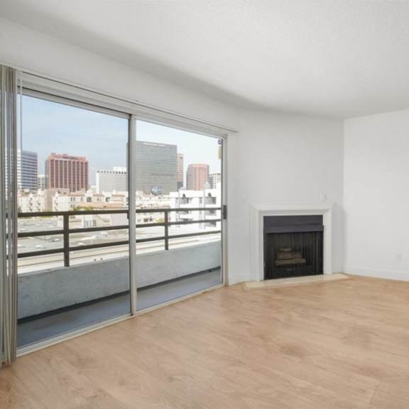 Thumbnail 12 of 24 A room with a fireplace and a view of the city.