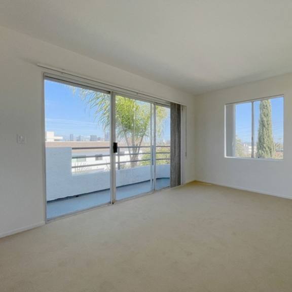 Thumbnail 51 of 53 A room with a sliding glass door leading to a balcony.
