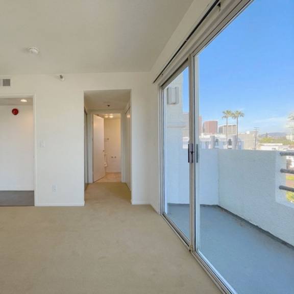 Thumbnail 50 of 53 A room with a sliding glass door leading to a balcony.