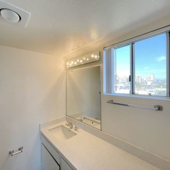 Thumbnail 47 of 53 A bathroom with a white sink and a window overlooking a cityscape.