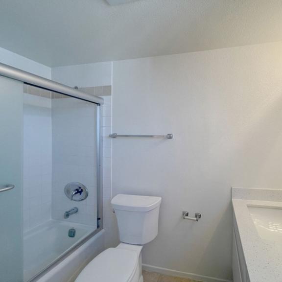 Thumbnail 52 of 53 A white toilet is in a bathroom with a sink and mirror.